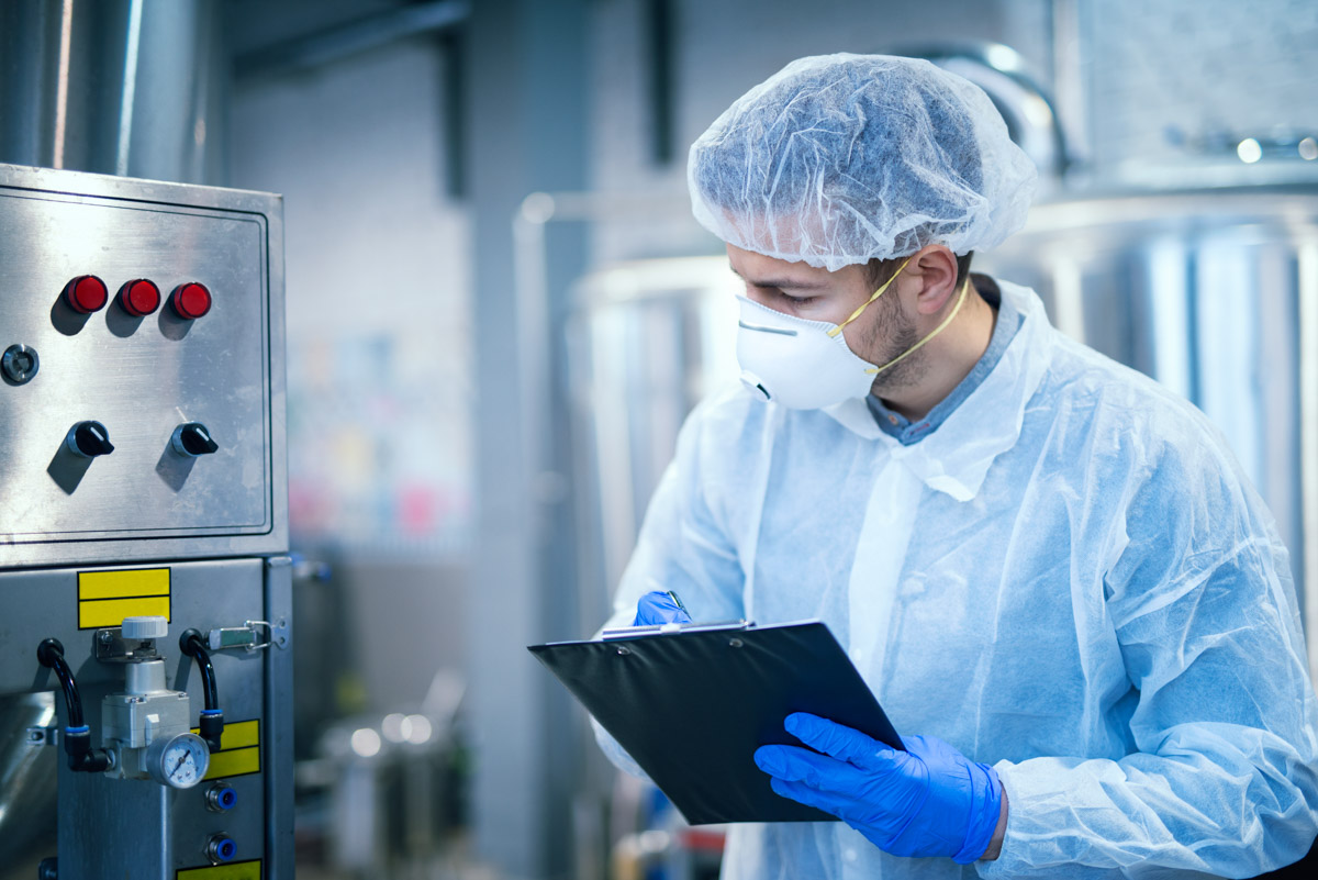 Technologist expert in protective uniform with hairnet and mask